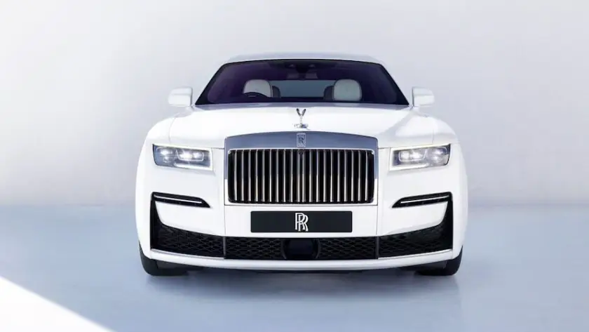 White Rolls-Royce luxury sedan front view in minimalist white studio setting