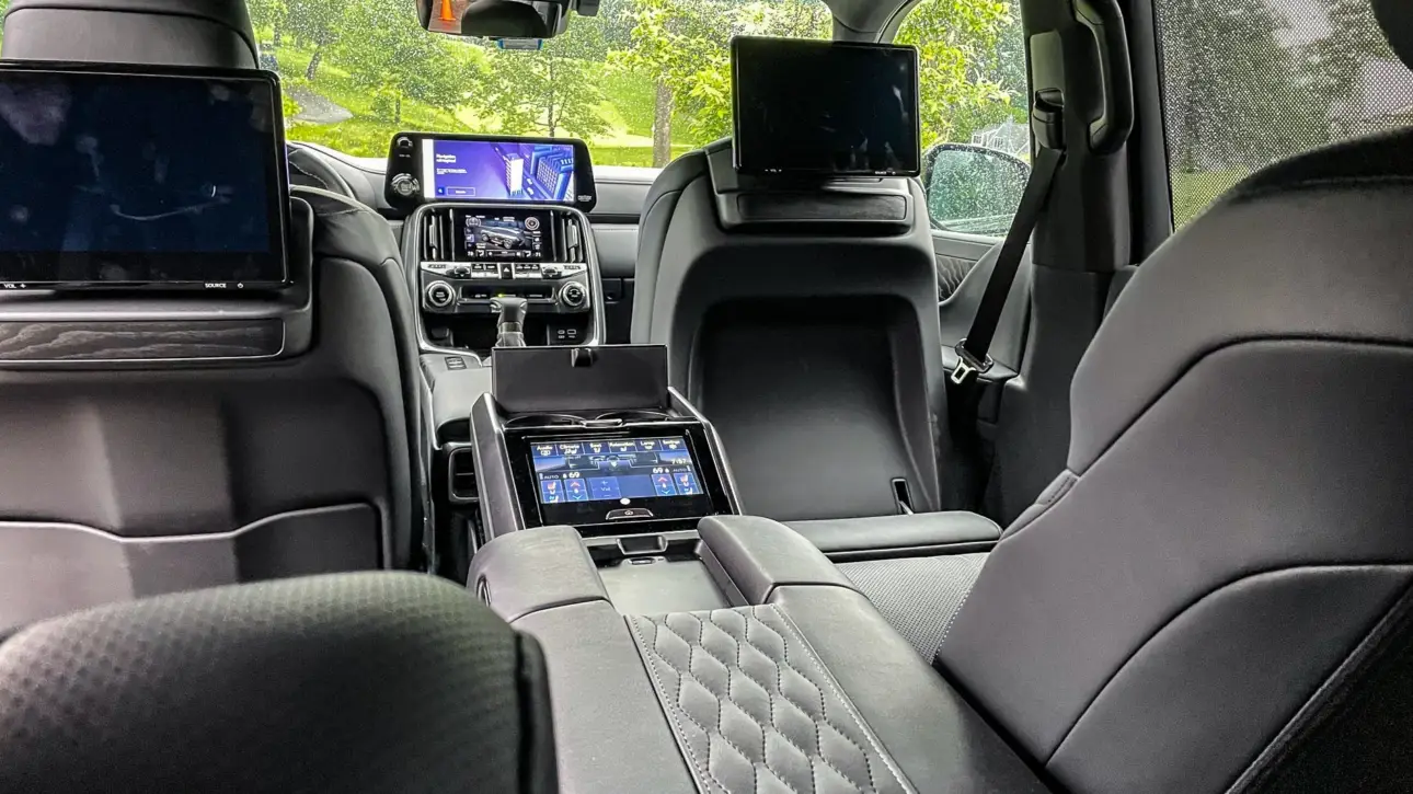 Luxury SUV interior with black quilted leather seats, entertainment screens and premium center console