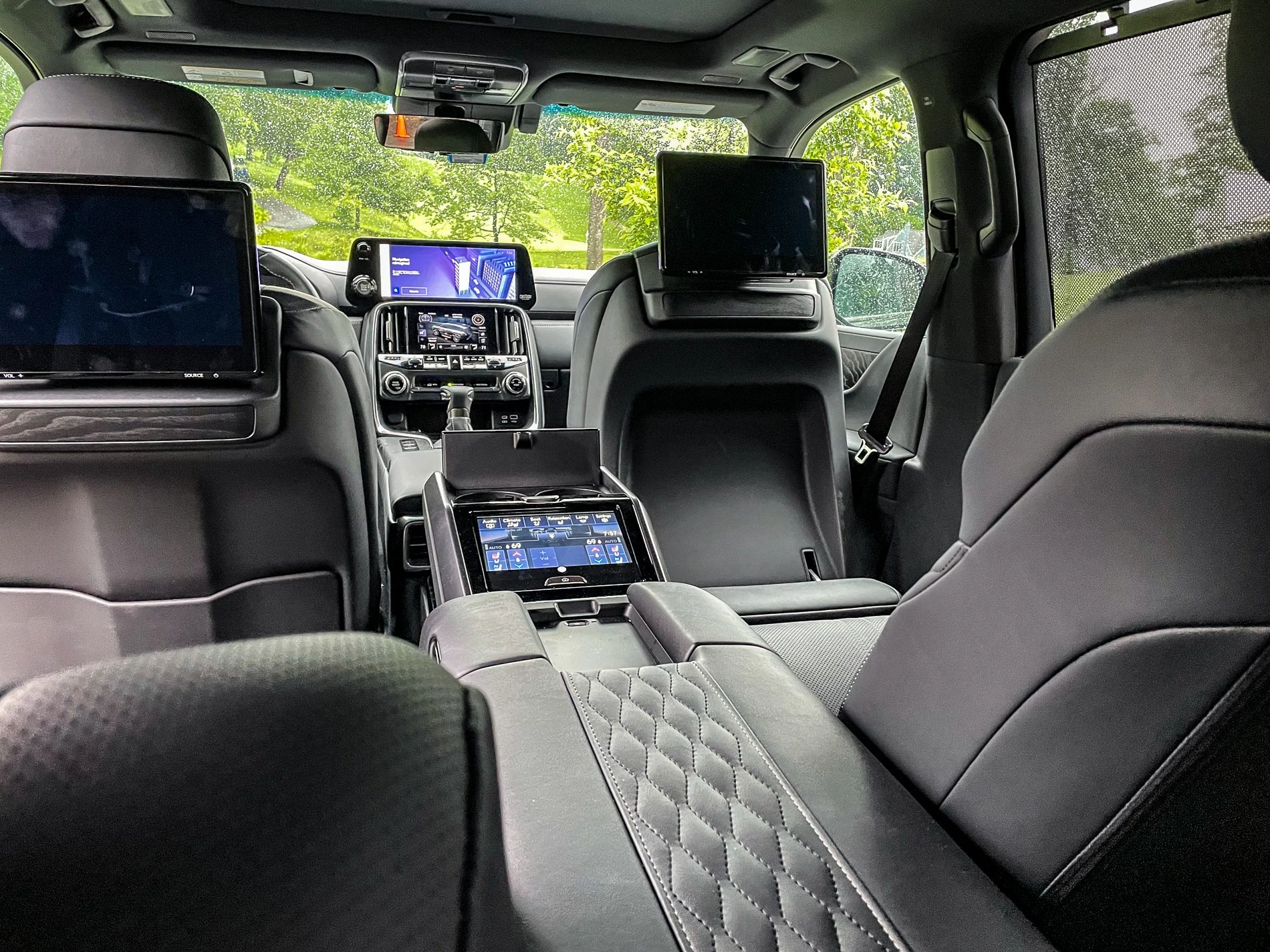 Luxury SUV interior with black quilted leather seats, entertainment screens and premium center console