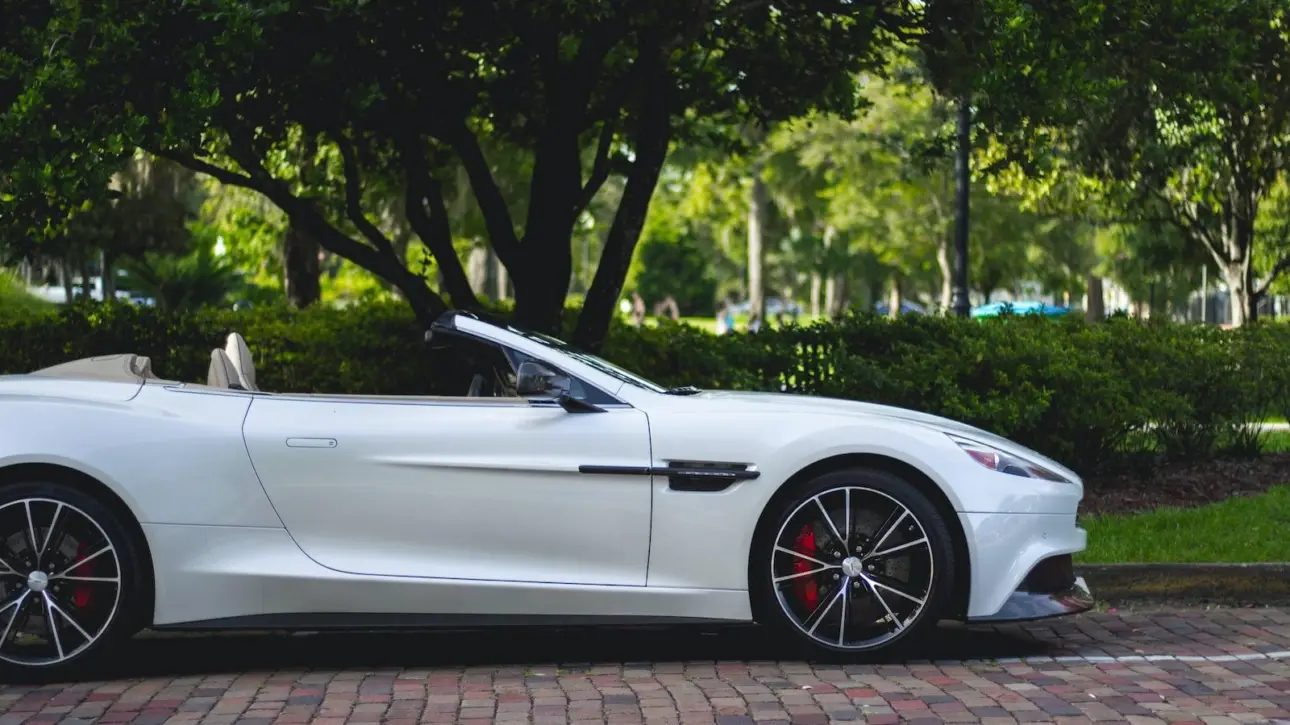 White Aston Martin convertible parked in scenic park setting showcasing luxury exotic car magnificence