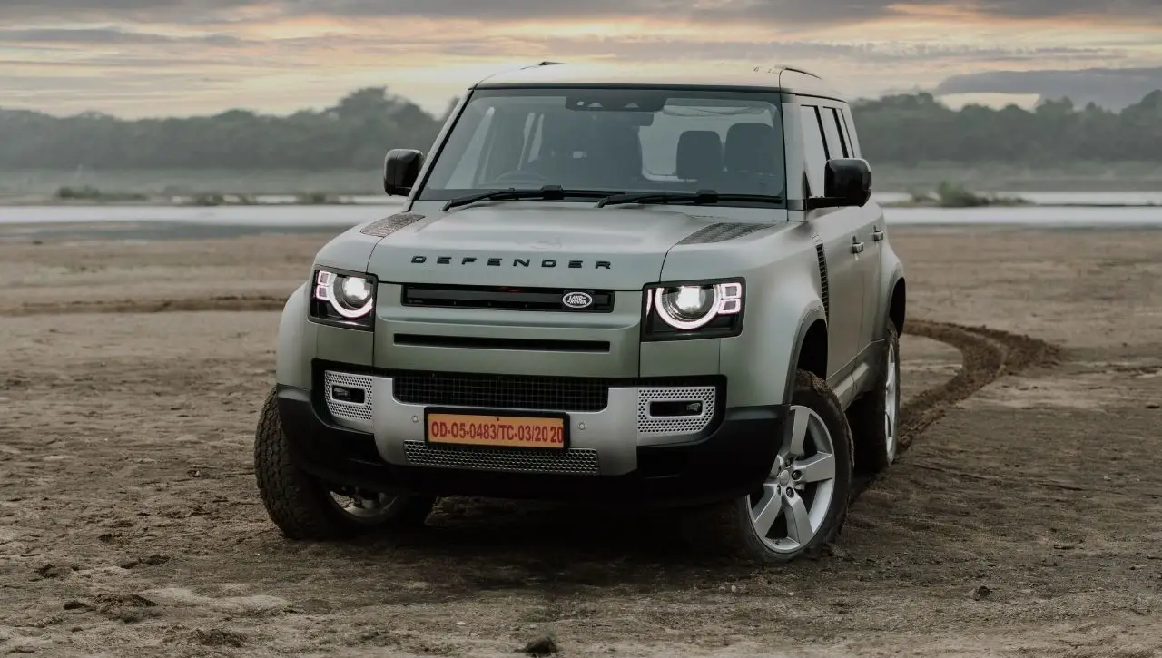 Land Rover Defender SUV on beach at sunset exploring Japanese SUVs from humble beginnings to global icons