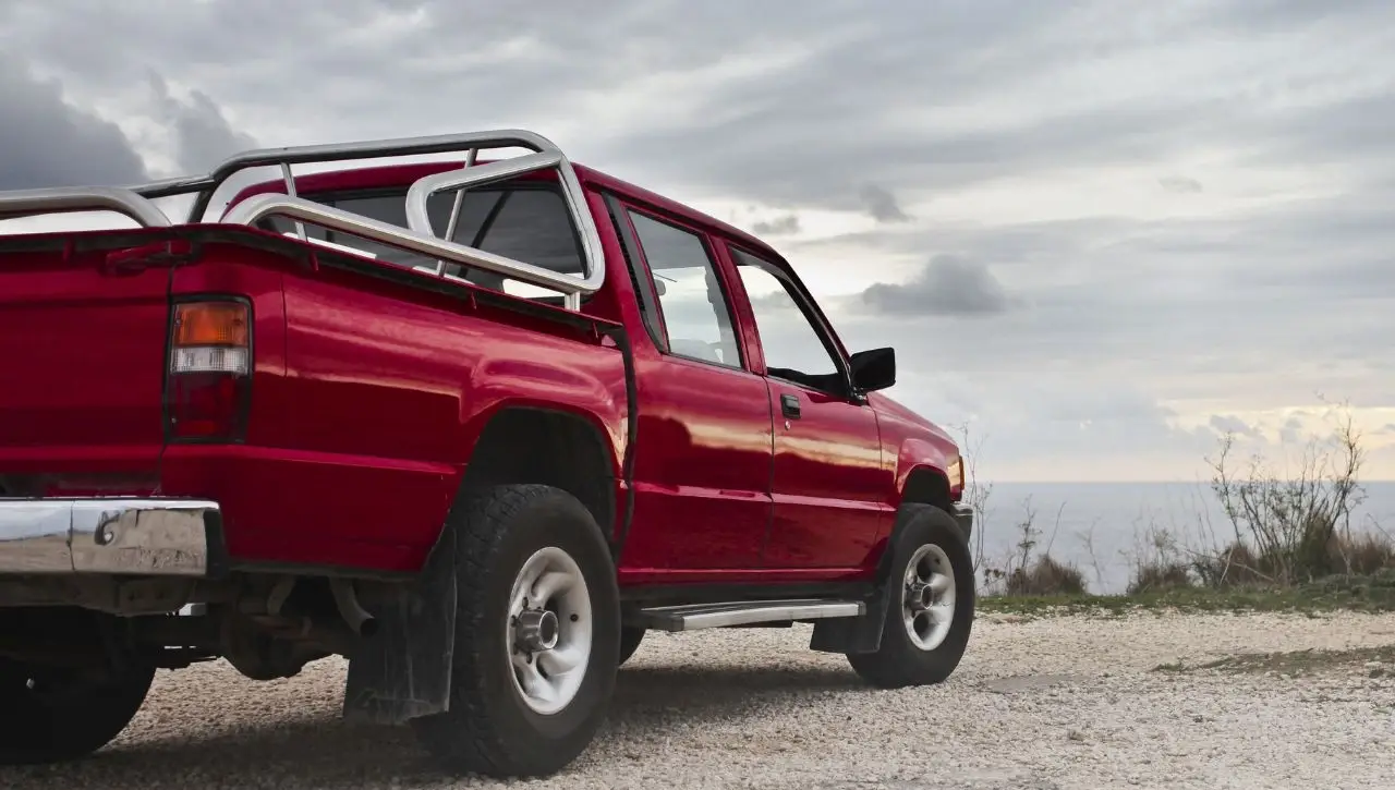 Red pickup truck with roll cage and lift kit modifications showcasing ultimate guide to truck customization