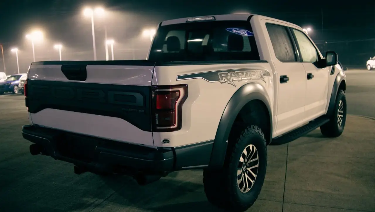 White Ford Ranger pickup truck with dark trim photographed at night in parking lot under street lights