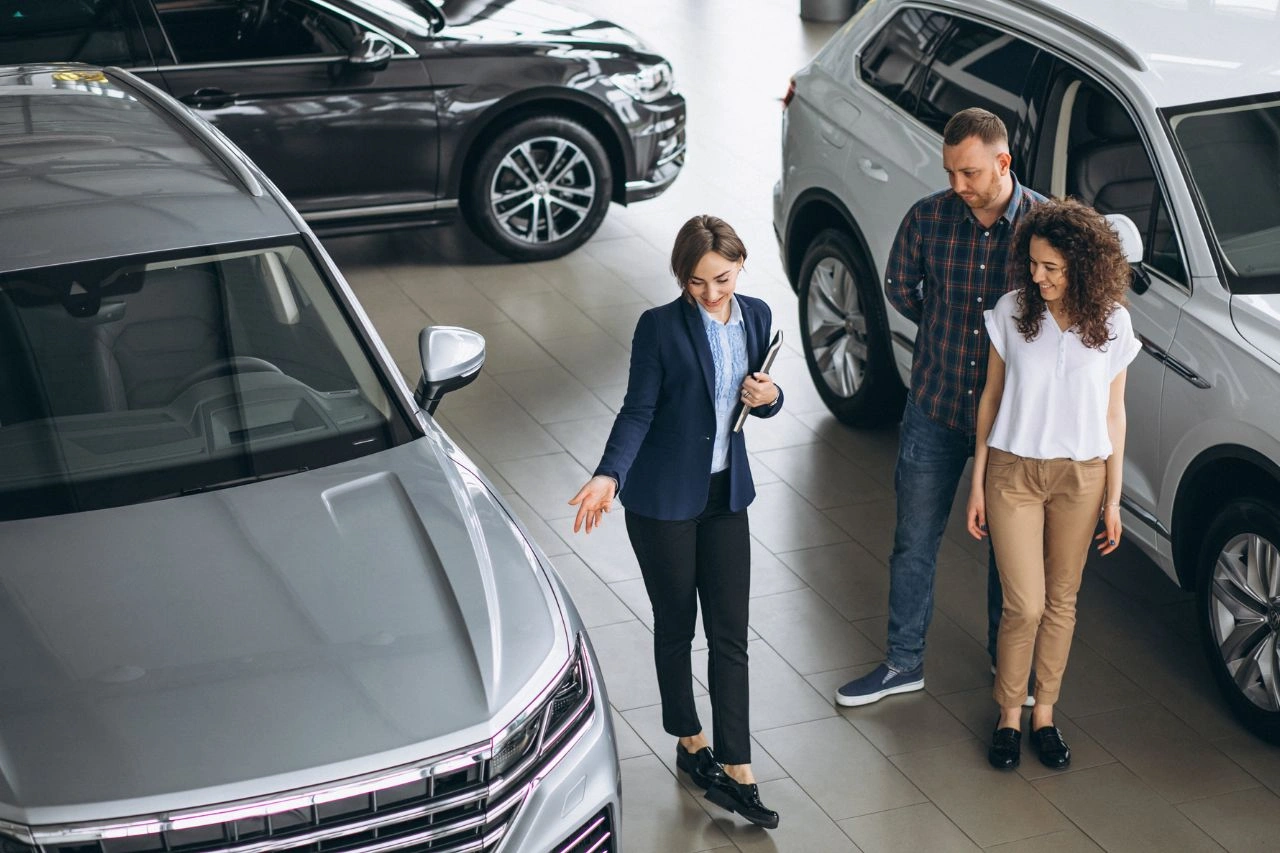 Group consultation at luxury car showroom discussing how to maintain imported car for longevity and performance