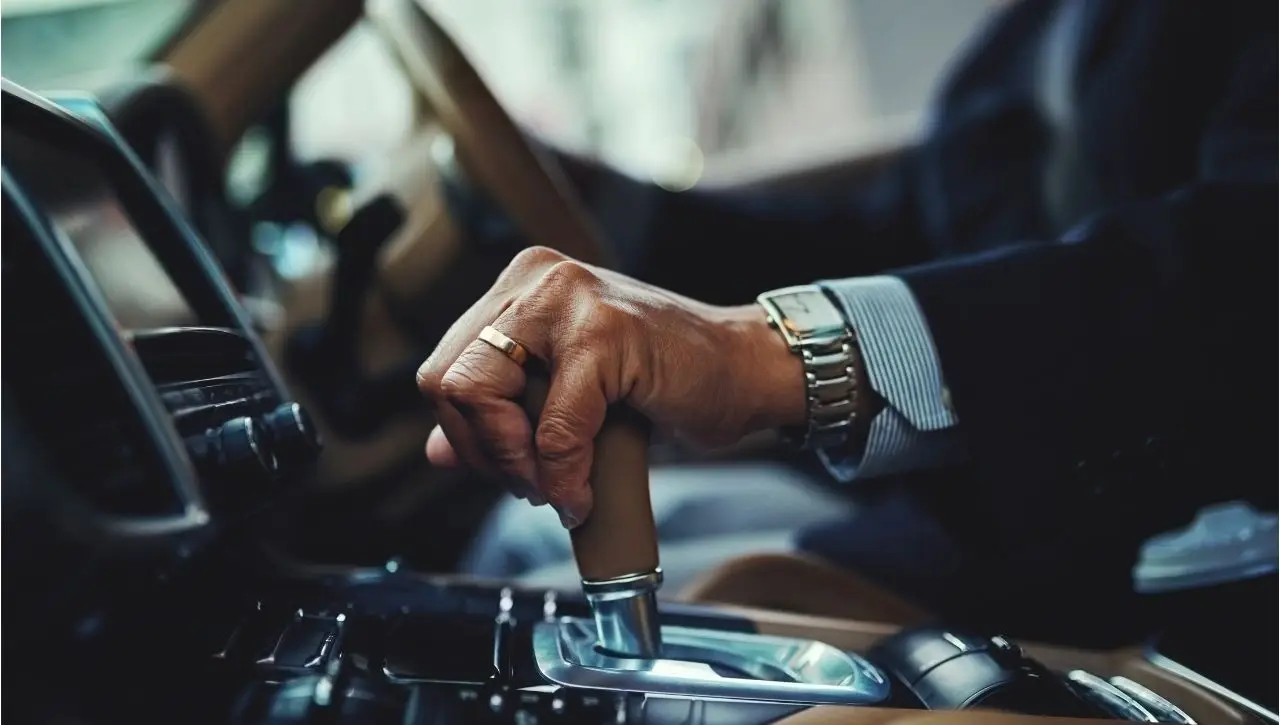 Person using gear shift in European car exploring why some European cars are right-hand drive and global driving norms