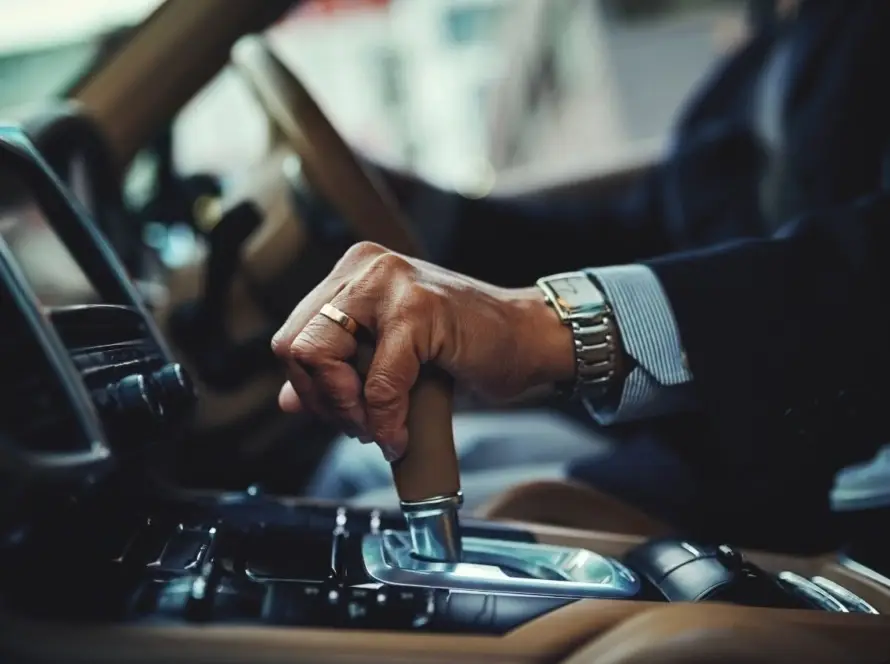 Person using gear shift in European car exploring why some European cars are right-hand drive and global driving norms