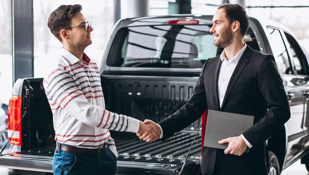 Two men shaking hands at dealership completing muscle car sale best American powerhouses you can own in India