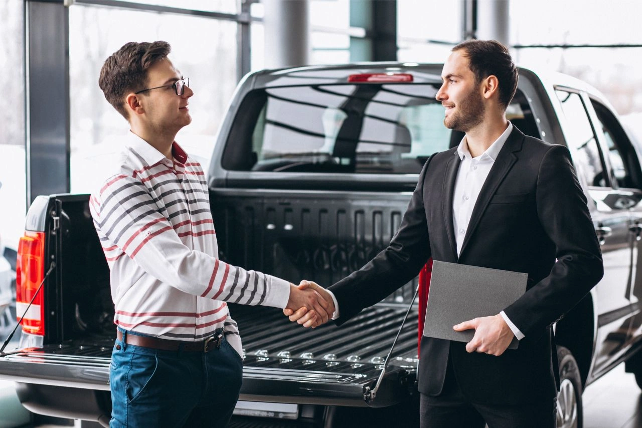 Two men shaking hands at dealership completing muscle car sale best American powerhouses you can own in India