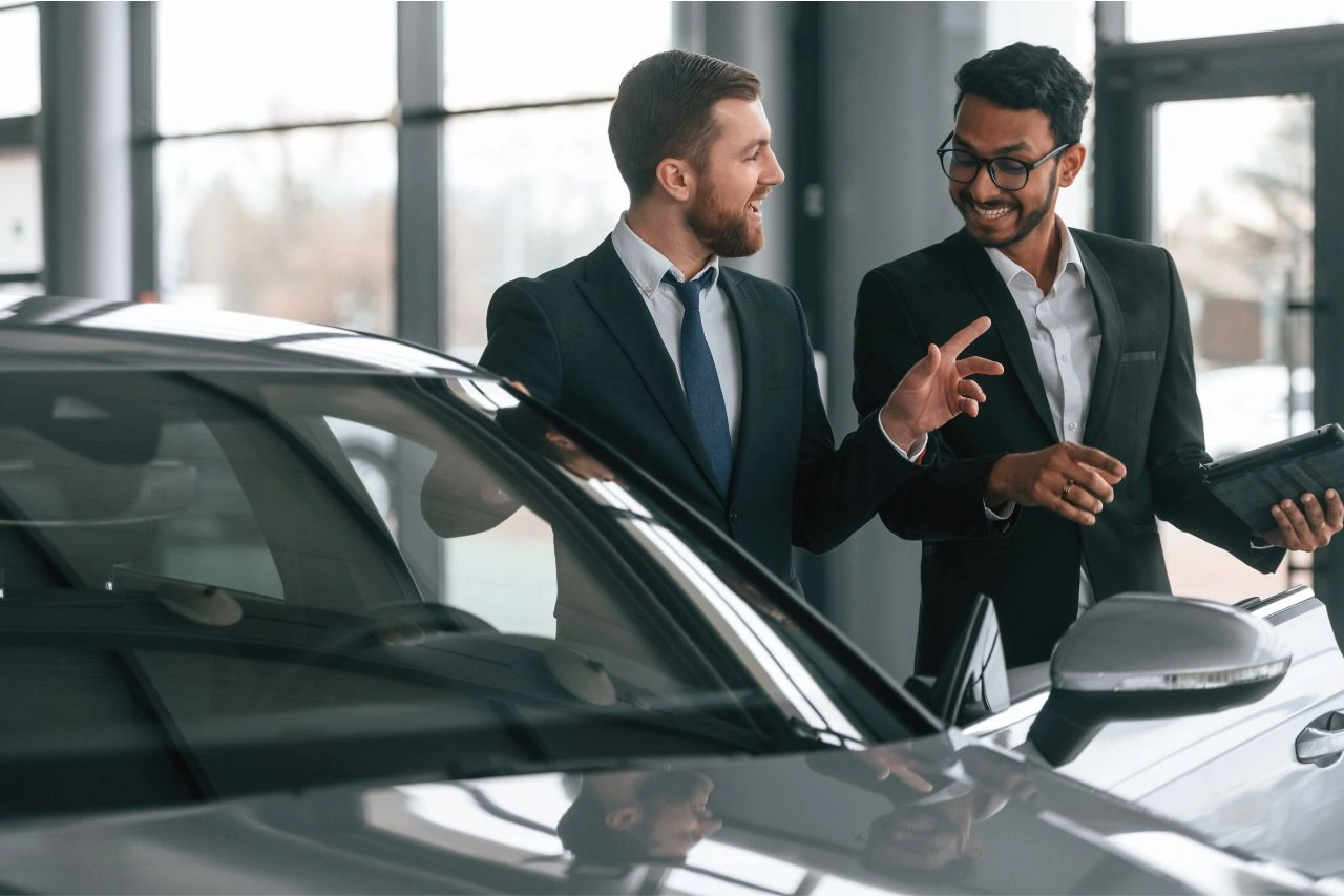 Two professional men discussing imported car dealership options where to buy your dream car in India