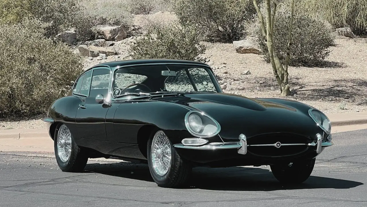 Dark green Jaguar E-Type coupe classic sports car in desert 1965-75 roadster guide which style suits you best