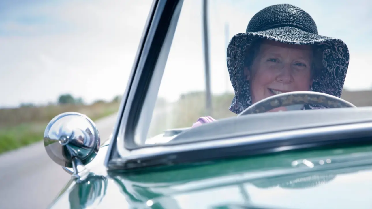 Mature woman with hat driving vintage Jaguar MK2 convertible British icon revisited exploring timeless charm of 1959-67 classic