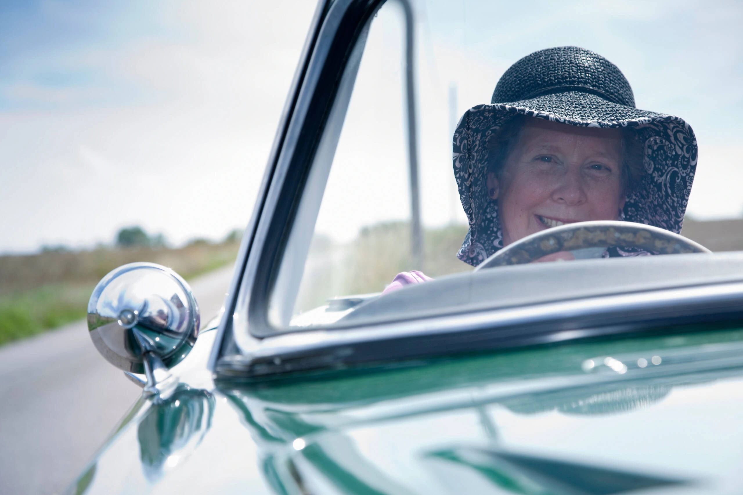 Mature woman with hat driving vintage Jaguar MK2 convertible British icon revisited exploring timeless charm of 1959-67 classic