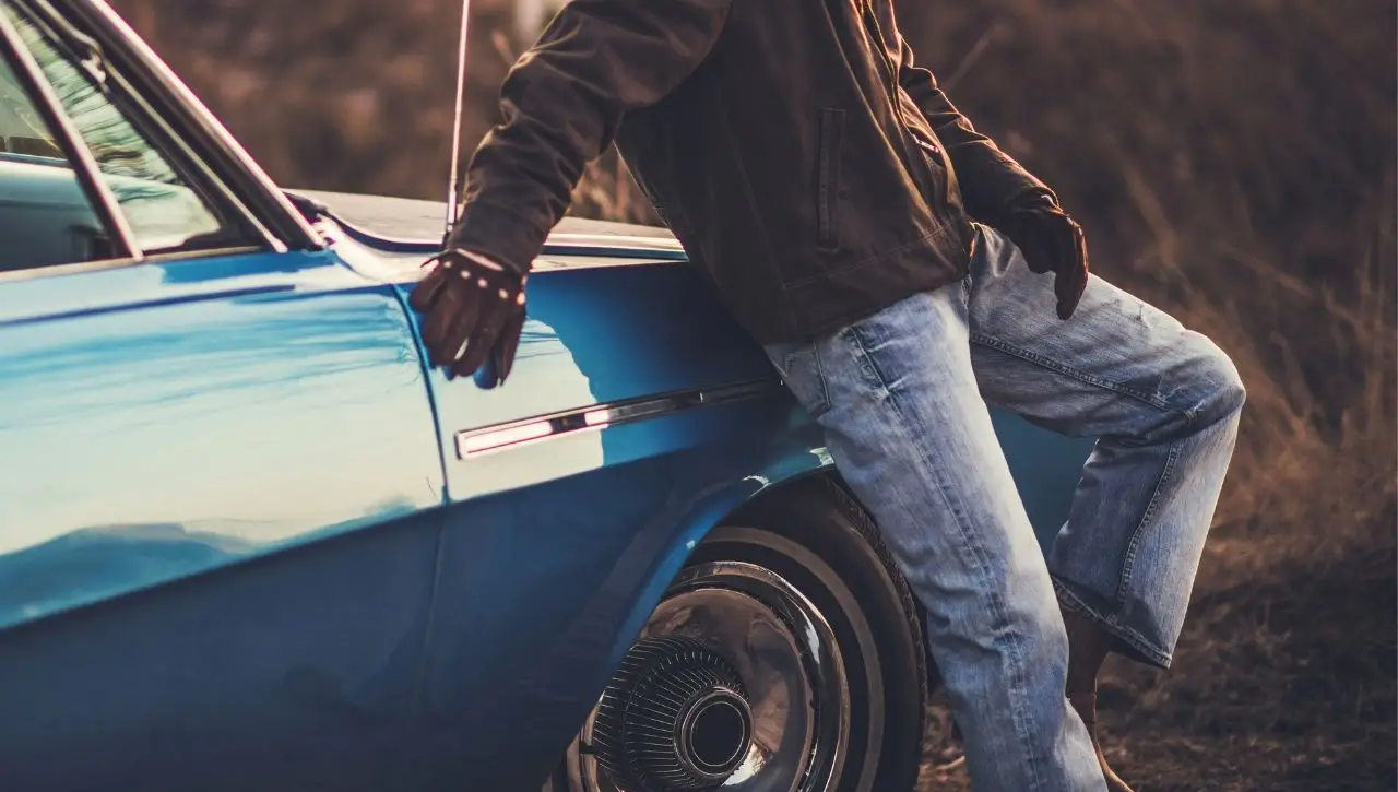 Person sitting on vintage blue muscle car at sunset top 6 American muscle coupes of 60s and 70s you can still get in India