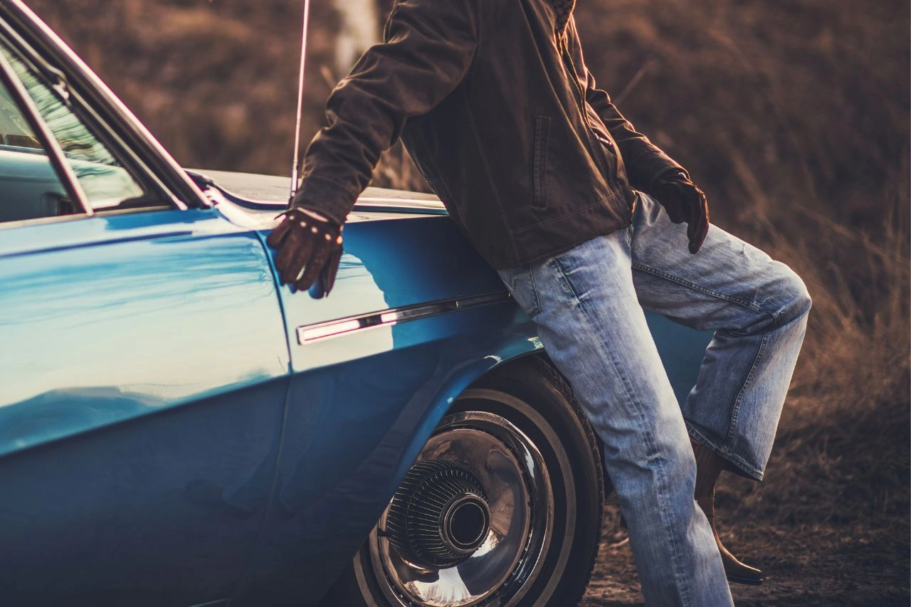 Person sitting on vintage blue muscle car at sunset top 6 American muscle coupes of 60s and 70s you can still get in India