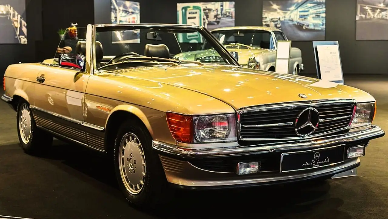 Gold Mercedes-Benz SL R107 convertible in showroom timeless style why 1971-1975 model is worth so much more today