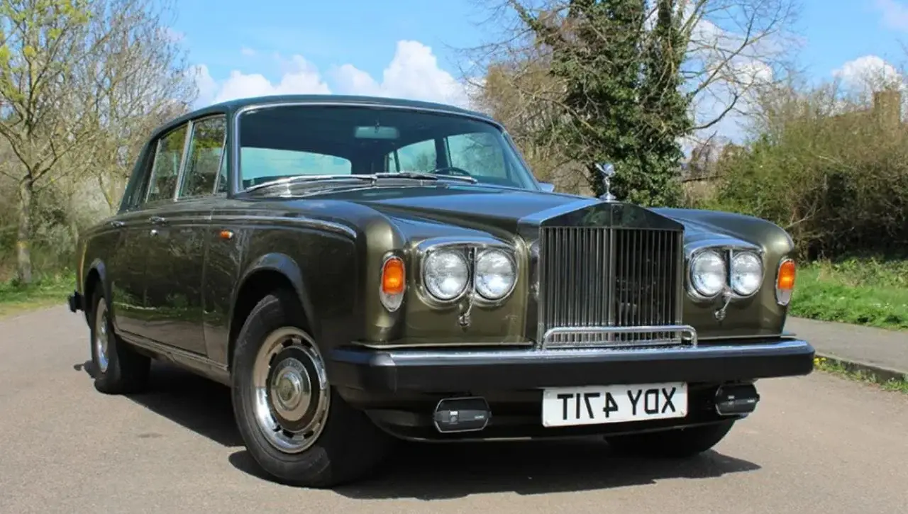 Classic olive brown Rolls-Royce Silver Ghost vintage luxury car on rural road