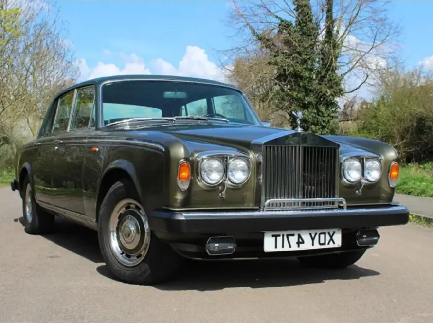 Classic olive brown Rolls-Royce Silver Ghost vintage luxury car on rural road
