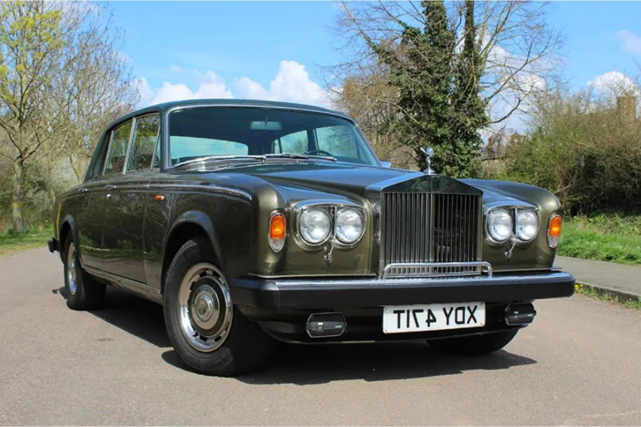 Classic olive brown Rolls-Royce Silver Ghost vintage luxury car on rural road