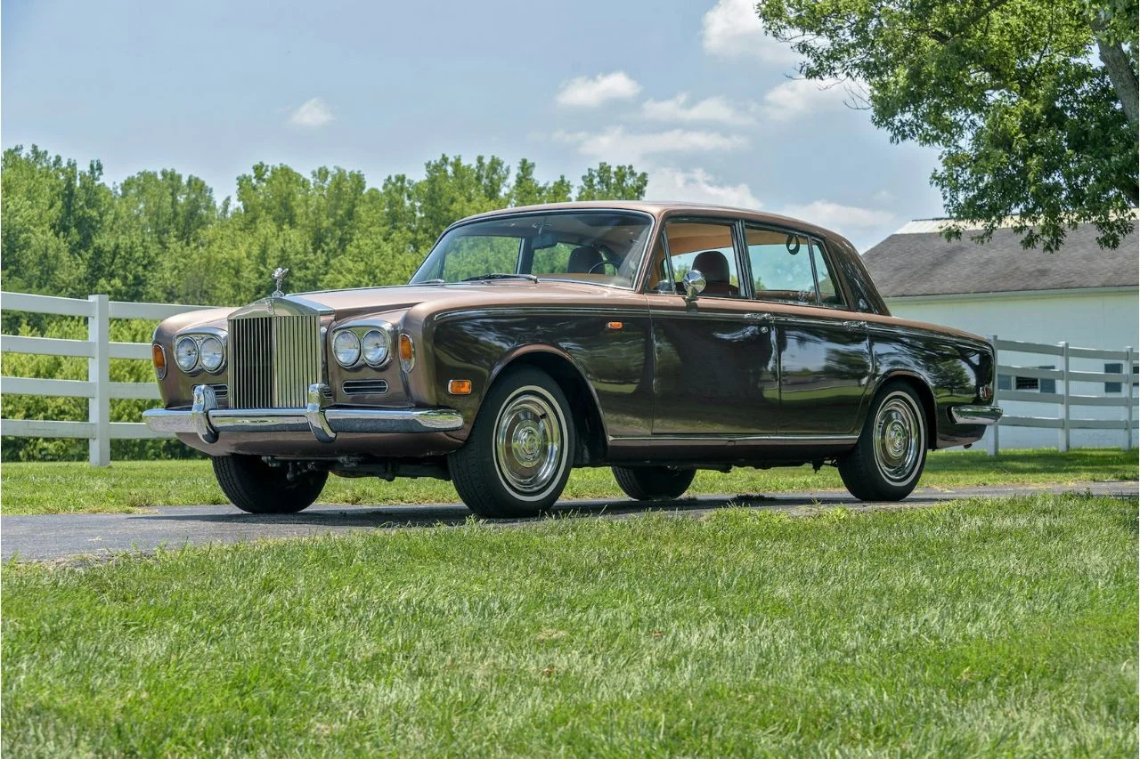 Classic dark green Rolls-Royce Silver Shadow II luxury sedan from 1970s on grass field