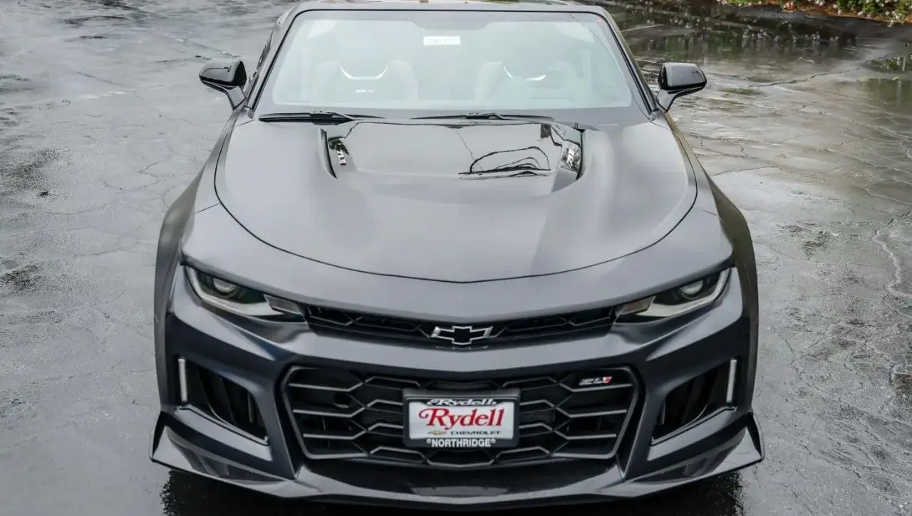 Front view of dark gray Chevrolet Camaro with aggressive black grille and hood scoop