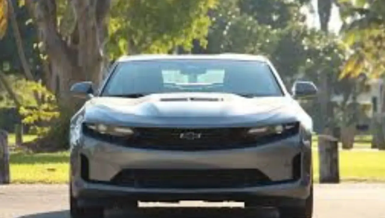 Front view of blue Chevrolet Camaro LT1 muscle car on tree-lined street
