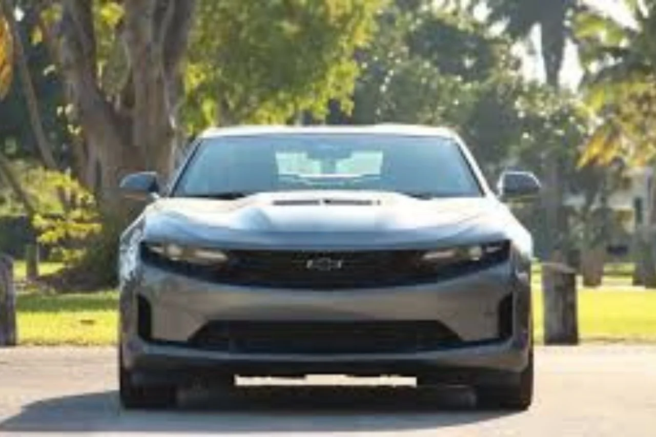 Front view of blue Chevrolet Camaro LT1 muscle car on tree-lined street
